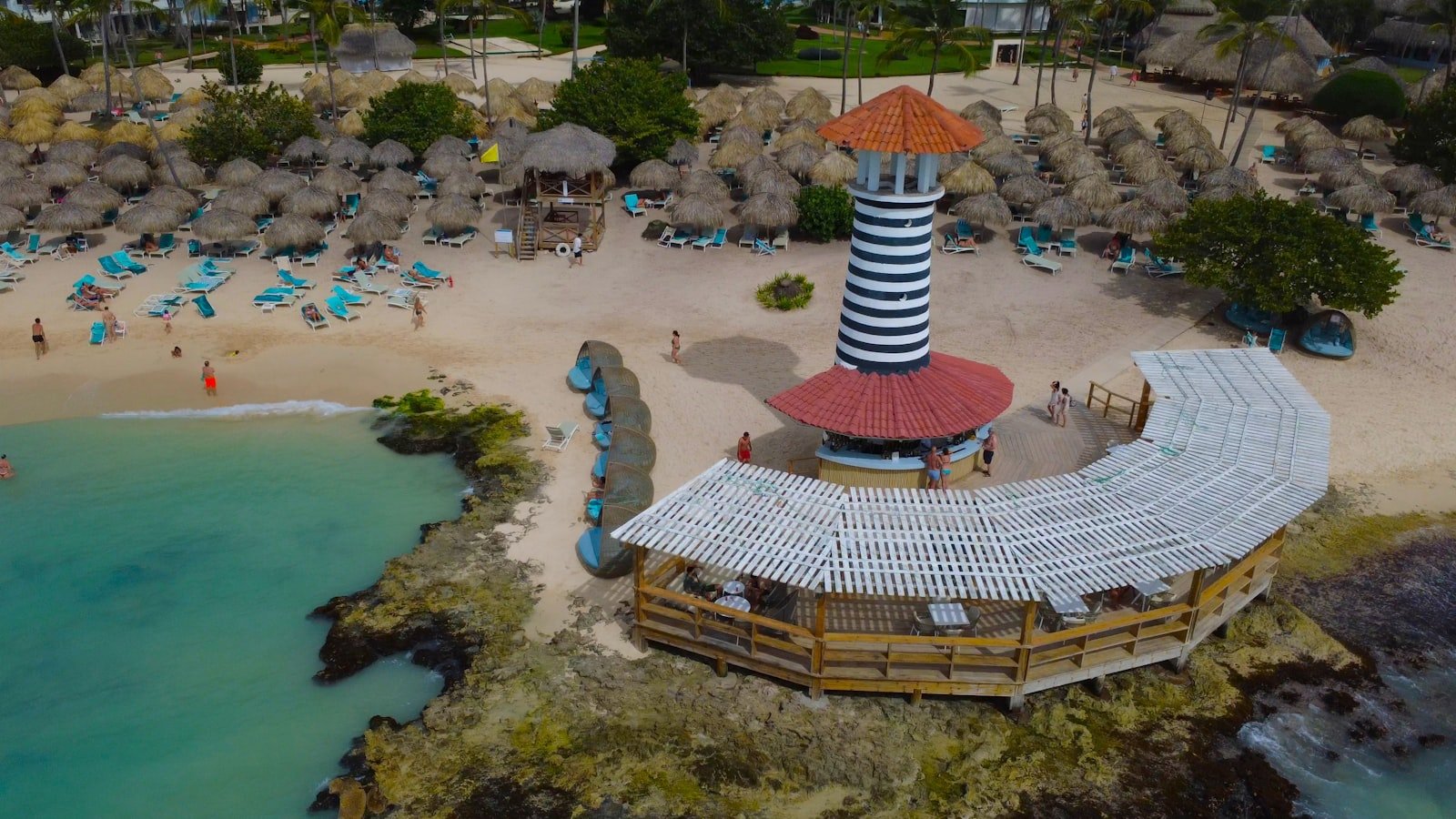 Striped lighthouse beside the beach and sea in Dominicus
